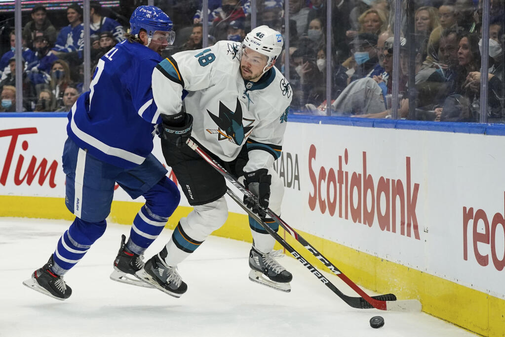 San Jose Sharks forward Tomas Hertl, right, spins away from Toronto Maple Leafs defenseman Justin Holl during the third period on Friday, Oct. 22, 2021, in Toronto. (Evan Buhler / Canadian Press)