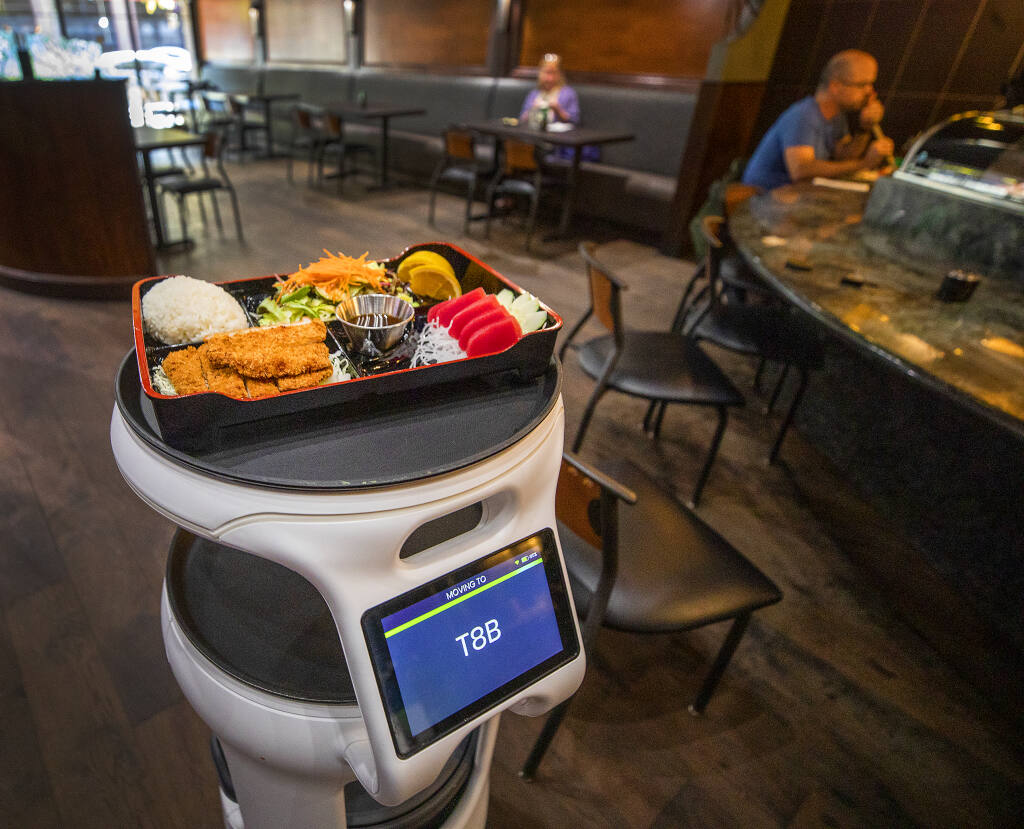 A robot brings a bento box lunch to a diner at Sushi Rosa in downtown Santa Rosa on Friday, Oct. 10, 2021. (Mariah Hanson)