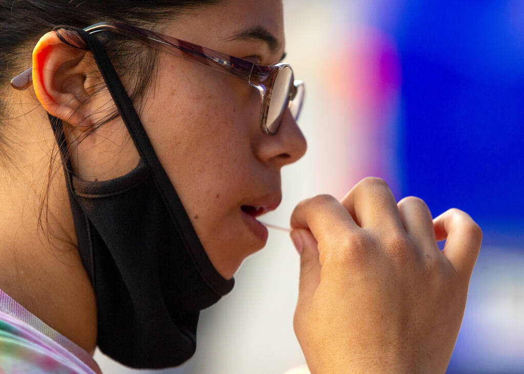 Maria Zepeda swabs her mouth during mobile COVID-19 testing at the Healdsburg Community Center in Healdsburg on Tuesday, Aug. 25, 2020. (Alvin A.H. Jornada / The Press Democrat)