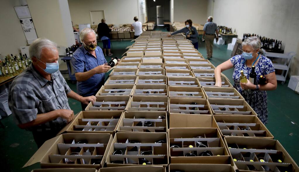 Volunteers for the North Coast Wine Challenge sort wines to be judged, Wednesday, July 15, 2020 at the Sonoma County Fairgrounds in Santa Rosa. (Kent Porter / The Press Democrat) 2020