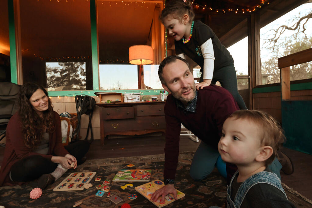 Sabrina Niemiec, far left, who is pregnant and due in July, watches her husband Collin Niemiec play with their children Isla, 3, and Nico, 19-months, far right, at their home in Forestville, Calif. on Friday, Jan. 27, 2023.(Erik Castro / For The Press Democrat)