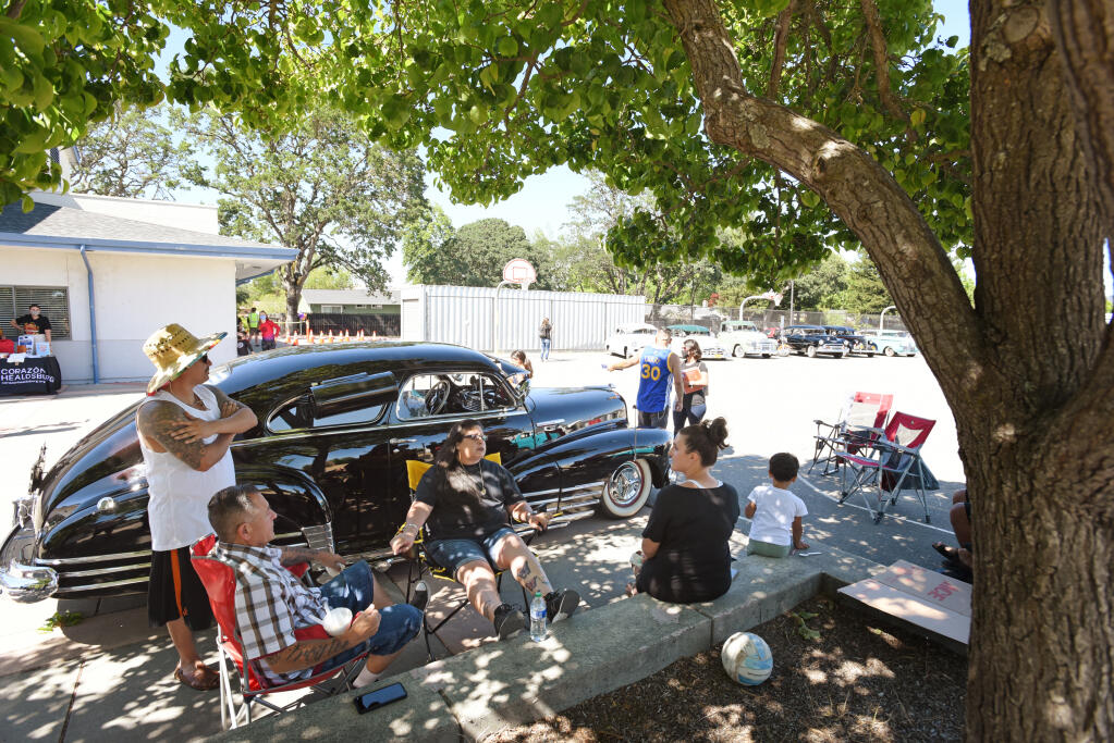 Attendees relax in the shade during a car show and free COVID-19 vaccine clinic for anyone 12 and older held at Cali Calmecac Language Academy in Windsor on Wednesday May 26, 2021. The event was sponsored by Corazon Healdsburg. (Erik Castro/for The Press Democrat)