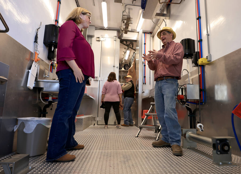 Adam Parks, owner of the Victorian Farmstead Meat Company of Sebastopol and vice president of the Bay Area Ranchers Co-op, talks with USDA Undersecretary Jenny Lester Moffitt, inside a mobile processing unit for livestock, Saturday, Feb.12, 2022. (Kent Porter / The Press Democrat)
