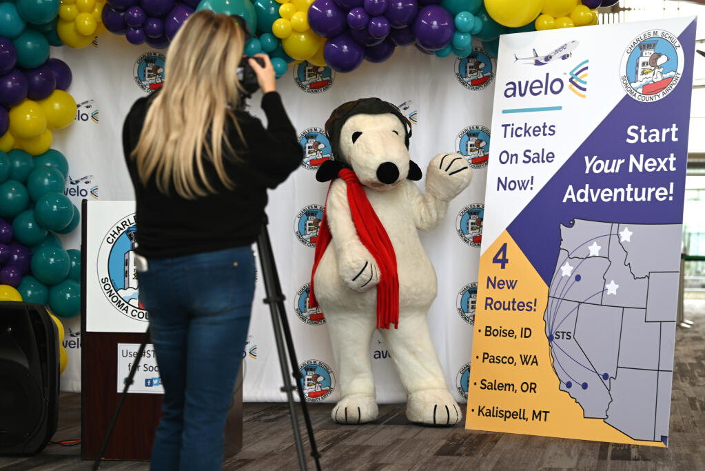 Snoopy posing for Avelo Airlines Multi-Media Content Manager Lauren Rovella during Avelo Airlines announcement of four new nonstop routes from Charles M. Schulz-Sonoma County Airport held at the airport’s baggage claim area in Santa Rosa, Wednesday, Feb. 21, 2024.  (Erik Castro / For The Press Democrat)
