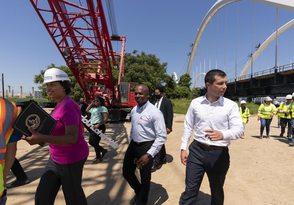 District of Columbia Mayor Muriel Bowser, left, and Secretary of Transportation Pete Buttigieg, right, visit the Frederick Douglass Memorial Bridge construction site in together with Secretary of Labor Marty Walsh, in southeast Washington, Wednesday, May 19, 2021. (AP Photo/Manuel Balce Ceneta)