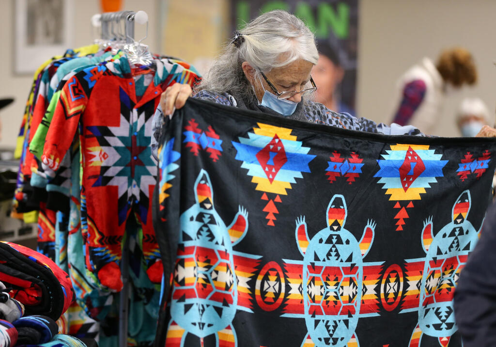 Lucy Harris looks at a blanket during the Native Holiday Art Fair at the California Indian Museum & Cultural Center in Santa Rosa on Sunday, Dec. 11, 2022. (Christopher Chung / The Press Democrat)