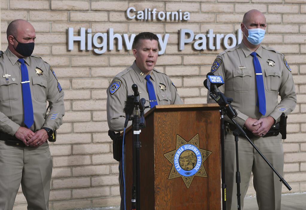 California Highway Patrol Captain Kevin Clays, center, updates the media about Friday's fatal crash on Highway 33 on Saturday, Jan. 2, 2021 in Coalinga, Calif. Investigators are asking for the public's help to determine what led up to a head-on crash that killed seven children and two adults in central California on New Year's Day.  (Eric Paul Zamora/The Fresno Bee via AP)