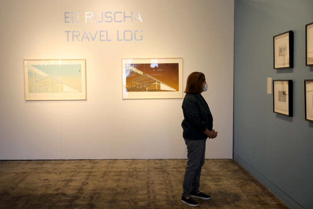 Museum volunteer Madeline Whittaker looks over the the exhibit "Ed Ruscha: Travel Log" at the Sonoma Valley Museum of Art. Photo taken in Sonoma, California, on Wednesday, March 24, 2021. (Beth Schlanker/ The Press Democrat)