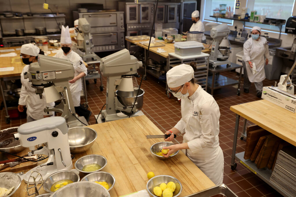 Student Leisha Tow zests lemons for curd during Specialty Production Baking class at Burdo Culinary Arts Center across from the Santa Rosa Junior College campus in Santa Rosa, Calif., on Tuesday, April 5, 2022. (Beth Schlanker/The Press Democrat)