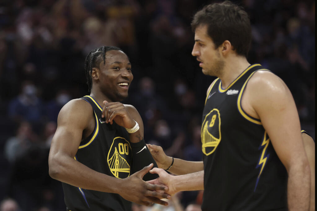 Golden State Warriors forward Jonathan Kuminga, left, is congratulated by teammate Nemanja Bjelica after scoring against the Dallas Mavericks during the second half in San Francisco on Tuesday, Jan. 25, 2022. (Jed Jacobsohn / ASSOCIATED PRESS)