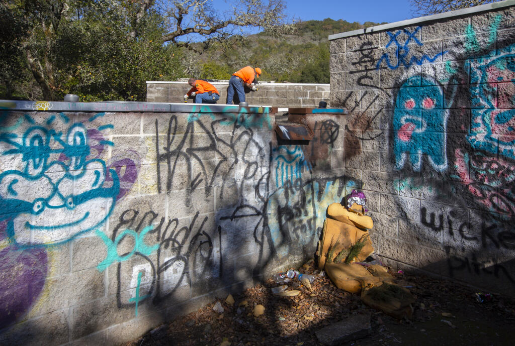 Public Works staff scrub down the walls at Mountain Cemetery on First Street West, which taggers have riddled with graffiti during the recent stay-at-home order. (Photo by Robbi Pengelly/Index-Tribune)