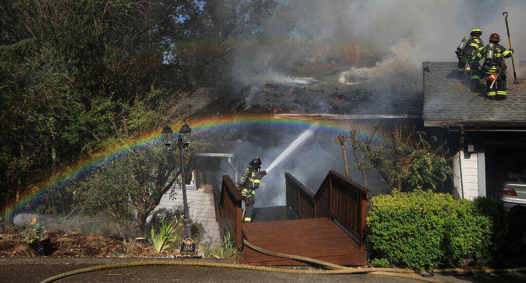 Fire breaches the roof as the Santa Rosa Fire Department keep it from spreading to the surrounding homes and vegetation on Happy Valley Road in Santa Rosa, Wednesday, June 1, 2022.  (Kent Porter / The Press Democrat) 2022