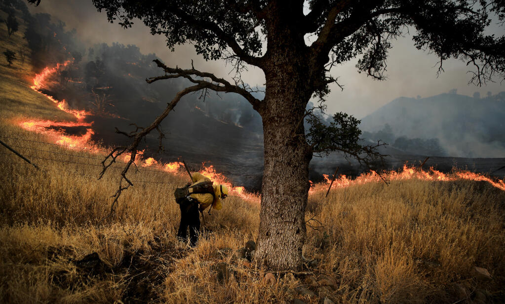 Along Highway 16 in Yolo County, fire crews monitor the eastern edge of the Hennessey fire as it backs down a mountain in Rumsey Canyon, Friday, Aug. 28, 2020.  (Kent Porter / The Press Democrat) 2020