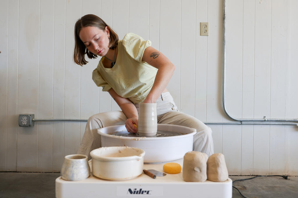 Kaylee Weeks shapes clay into a vase on a pottery wheel at Kickwheel Sonoma in Petaluma, Tuesday, Oct. 3, 2023. (Christopher Chung / The Press Democrat)