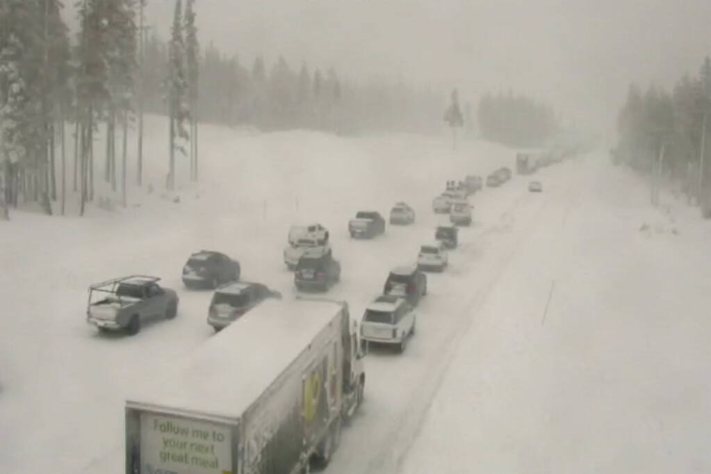 In this image taken from video from a Caltrans remote video traffic camera, traffic is stopped along a snow covered Interstate 80 at Donner Summit, Calif., on Thursday, Dec. 23, 2021. Heavy overnight rains in Northern California left two people dead in a submerged car as authorities on Thursday urged residents of several Southern California mountain and canyon communities to voluntarily leave their homes because of possible mud and debris flows. (Caltrans via AP)