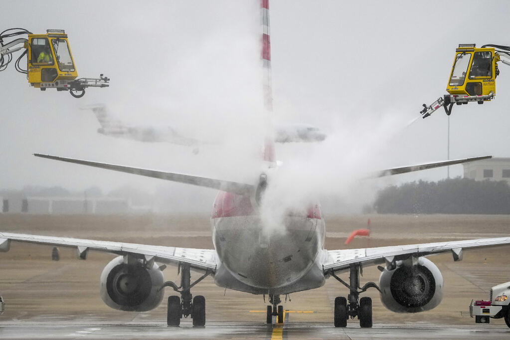 An American Airlines aircraft undergoes deicing procedures on Monday, Jan. 30, 2023, at Dallas/Fort Worth International Airport in Texas. (Lola Gomez/The Dallas Morning News via AP)