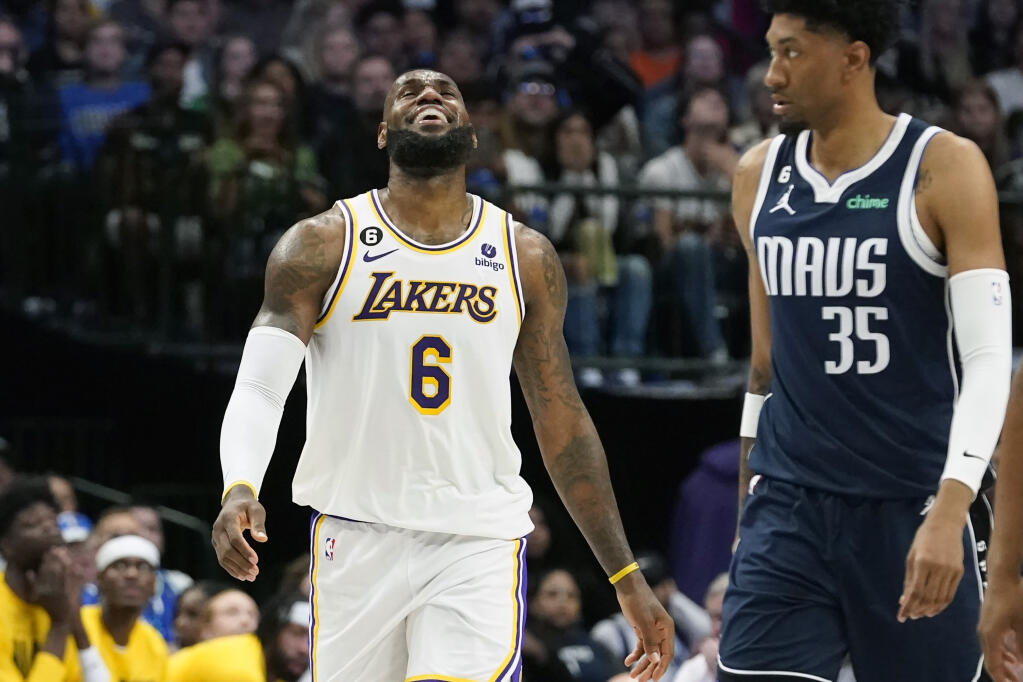 Los Angeles Lakers forward LeBron James (6) laughs next to Dallas Mavericks forward Christian Wood (35) during the second half of an NBA basketball game in Dallas, Sunday, Feb. 26, 2023. (AP Photo/LM Otero)