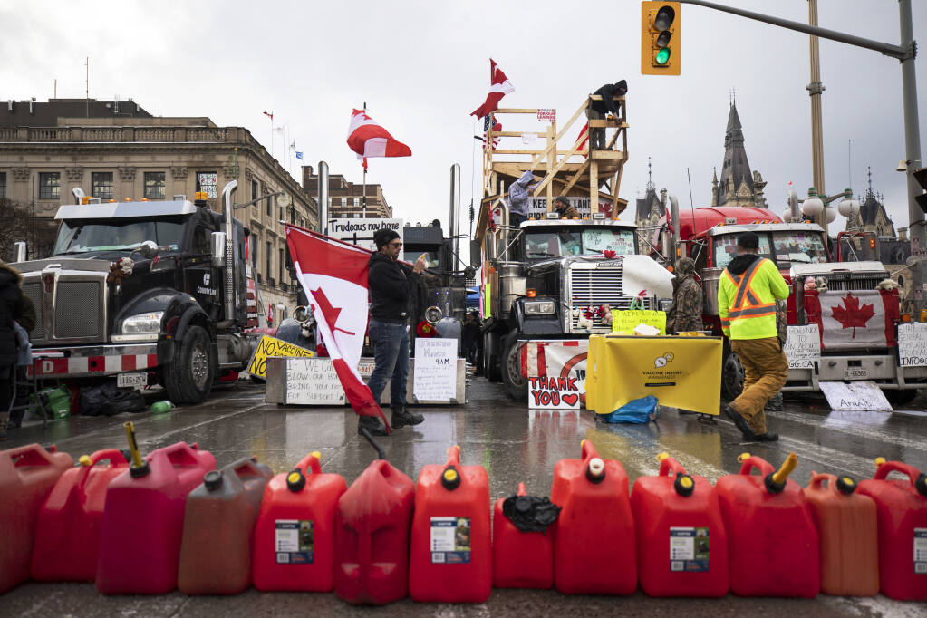 Protesters gather along Wellington Street as a protest against COVID-19 restrictions that has been marked by gridlock and the sound of truck horns reaches its 14th day, in Ottawa, Thursday, Feb. 10, 2022. (Nick Iwanyshyn/The Canadian Press via AP)