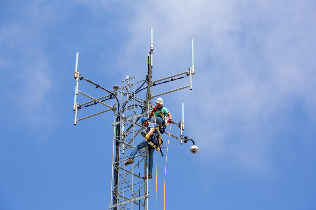 Dustin Mair, top, and Vince Hurst prepare to install a new camera on the top of the 80-foot tower at the Sheriff’s Office telecommunications facility at Sonoma Raceway on Thursday, July 15, 2021. (Photo by Robbi Pengelly/Index-Tribune)
