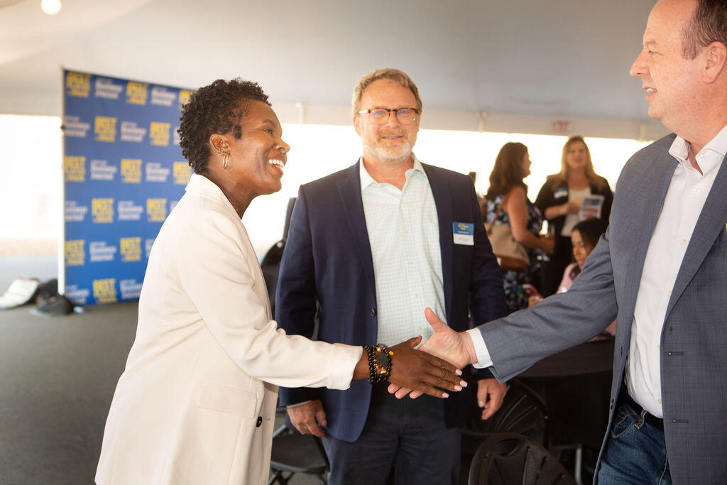 Kashi Moore-Stallworth, vice president of Human Relations for Redwood Credit Union (left), shakes hands with Aaron Collier, senior vice president of Information Technology for the credit union at the North Bay Business Journal's celebration of the Best Places to Work winners Sept.14 at the Luther Burbank Center for the Arts in Santa Rosa.  (Charles Gesell photo)