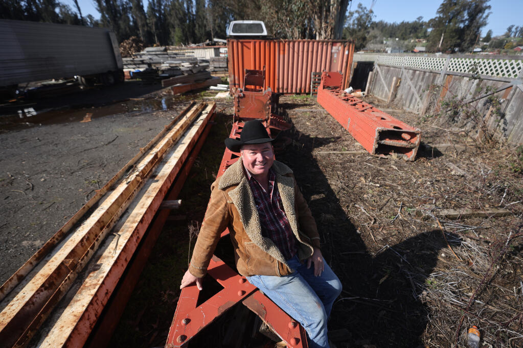 Justin McGrath sits on a piece of the Golden Gate Bridge that he purchased from auction and is now selling. Photo taken at Maestretti Firewood in Penngrove, Wednesday, March 15, 2023. (Beth Schlanker / The Press Democrat)