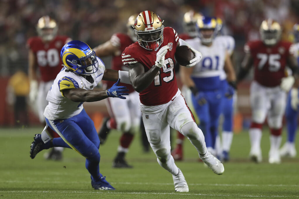 San Francisco 49ers wide receiver Deebo Samuel (19) runs past Los Angeles Rams safety Jordan Fuller to score during the second half of an NFL football game in Santa Clara, Calif., Monday, Nov. 15, 2021. (AP Photo/Jed Jacobsohn)