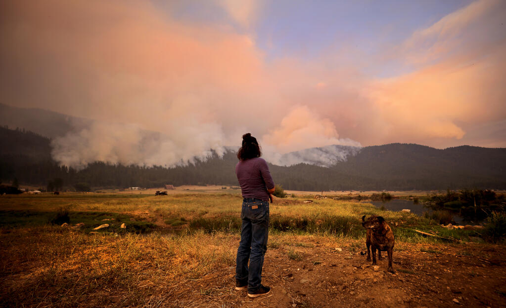 Marsha Melton of Greenville watches as the Dixie fire burns into Indian Valley, Sunday, July 8, 2021. Greenville, with a population of about 1,200, was obliterated by the nearly 500,000-acre fire.  (Kent Porter / The Press Democrat)