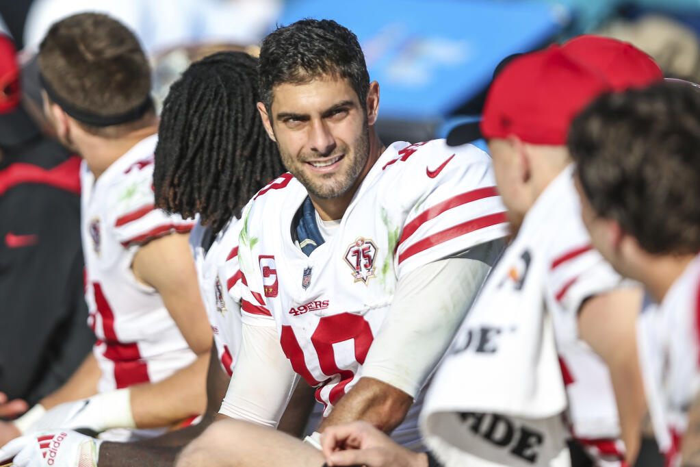 San Francisco 49ers quarterback Jimmy Garoppolo talks with teammates on the bench during the second half against the Jacksonville Jaguars on Sunday, Nov. 21, 2021, in Jacksonville, Florida. The 49ers defeated the Jaguars 30-10. (Gary McCullough / ASSOCIATED PRESS)