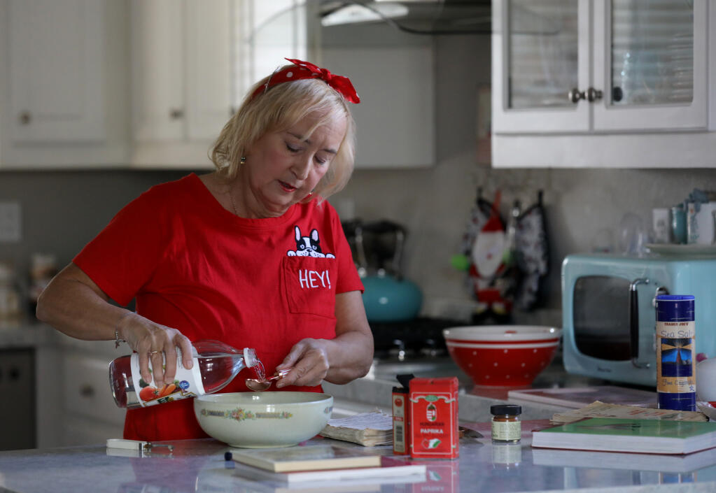 Shelley Shepherd-Klaner pours vinegar as she makes Hungarian cucumber salad at her home in Petaluma on Tuesday, Nov. 23, 2021. (Beth Schlanker/The Press Democrat)