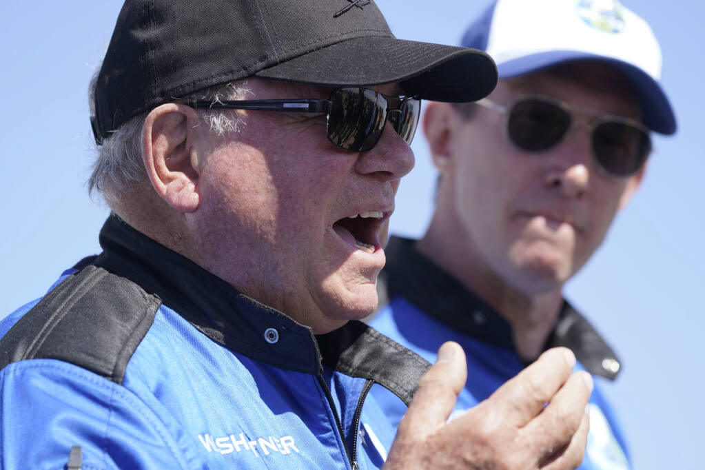 William Shatner, center, describes his flight on the Blue Origin as Glen de Vries looks on during a media availability at the spaceport near Van Horn, Texas, Wednesday, Oct. 13, 2021. (AP Photo/LM Otero)