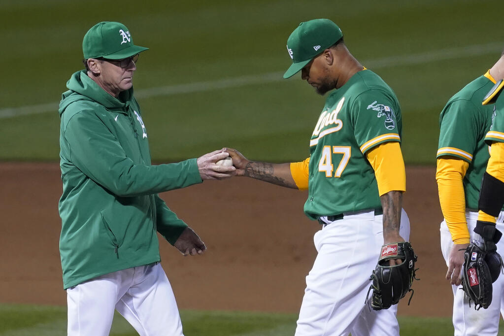 Oakland Athletics pitcher Frankie Montas hands the ball to manager Bob Melvin as he is taken out for a relief pitcher during the seventh inning against the Kansas City Royals in Oakland on Thursday, June 10, 2021. (Jeff Chiu / ASSOCIATED PRESS)