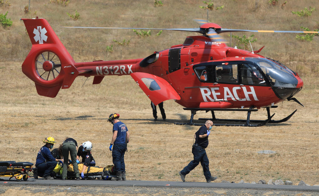 Healdsburg Fire Department and Bell's Ambulance Service personnel prepare to load a PG&E subcontractor into a REACH air ambulance, after the individual was injured helping to fell a tree off Palmer Creek Road in the Walbridge fire zone of the Mill Creek watershed, Thursday, Sept. 3, 2020 west of Healdsburg.  (Kent Porter / The Press Democrat) 2020