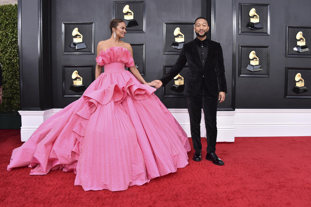 FILE - Chrissy Teigen, left, and John Legend arrive at the 64th Annual Grammy Awards at the MGM Grand Garden Arena on April 3, 2022, in Las Vegas. Chrissy Teigen and her husband John Legend are expecting another child nearly two years after the couple suffered a pregnancy loss. Teigen made the announcement Wednesday, Aug. 3, 2022, on Instagram where she posted two photos of her baby bump. (Photo by Jordan Strauss/Invision/AP, File)