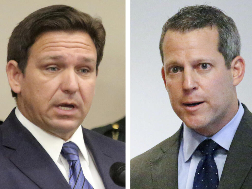 This combination of Thursday, Aug. 4, 2022 photos shows Florida Gov. Ron DeSantis, left, and Hillsborough County State Attorney Andrew Warren during separate news conferences in Tampa, Fla. On Sunday, Aug. 7, 2022, Warren vowed to fight his suspension from office by DeSantis over his promise not to enforce the state's 15-week abortion ban and support for gender transition treatments for minors. (Douglas R. Clifford/Tampa Bay Times via AP)