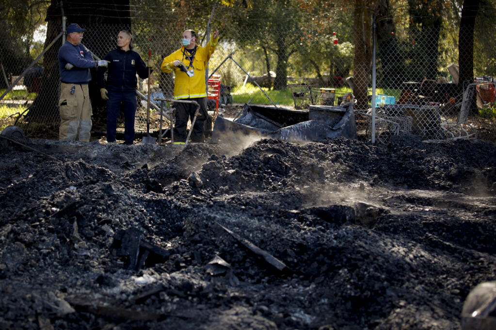 (L-R) John Teague of Graton Fire; Petaluma firefighter Shay Burke, lead investigator; and Joe Garcia, fire inspector, stand beside the burned remains of the historical Bloom-Tunstall House at Cedar Grove on Monday, Jan. 31, 2022, in Petaluma. (CRISSY PASCUAL/ARGUS-COURIER STAFF)