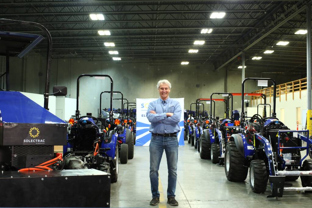 Solectrac Chief Innovation Officer Steve Heckeroth stands among the company’s electric tractors. He is seeing his dream of such vehicles coming come true. (courtesy of Ideanomics)