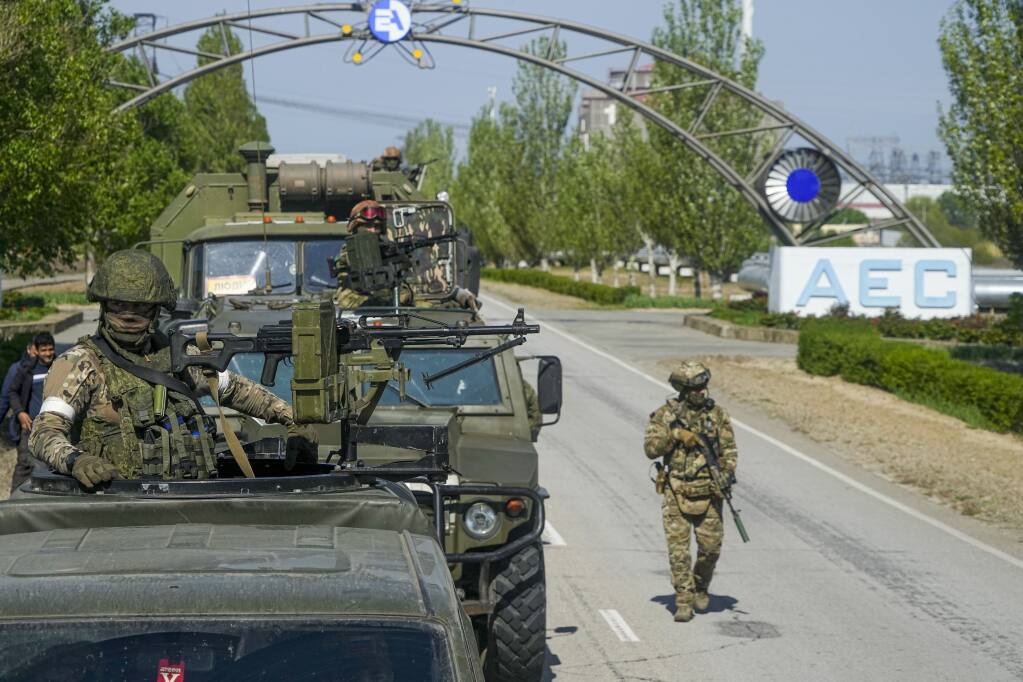 FILE - A Russian military convoy is seen on the road toward the Zaporizhzhia Nuclear Power Station, in Enerhodar, Zaporizhzhia region, in territory under Russian military control, southeastern Ukraine, on May 1, 2022. The Zaporizhzhia plant is in southern Ukraine, near the town of Enerhodar on the banks of the Dnieper River. It is one of the 10 biggest nuclear plants in the world. Russia and Ukraine have accused each other of shelling Europe's largest nuclear power plant, stoking international fears of a catastrophe on the continent.  This photo was taken during a trip organized by the Russian Ministry of Defense. (AP Photo, File)