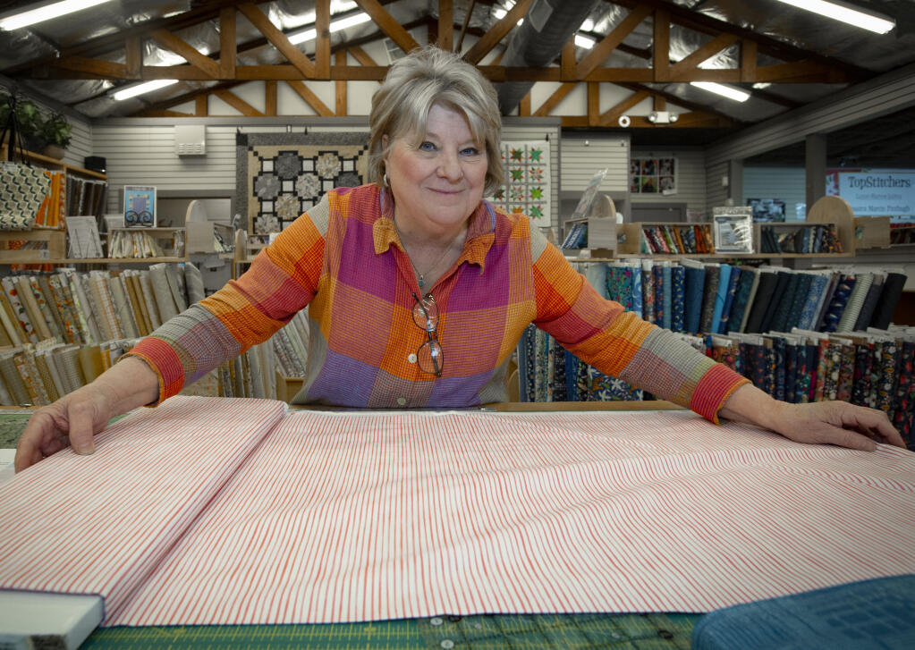 Gerry Rosemurgy, proprietor of Broadway Quilts, prepares to cut some fabric at her shop on Broadway on Wednesday, Feb. 23, 2022. (Robbi Pengelly/Index-Tribune)