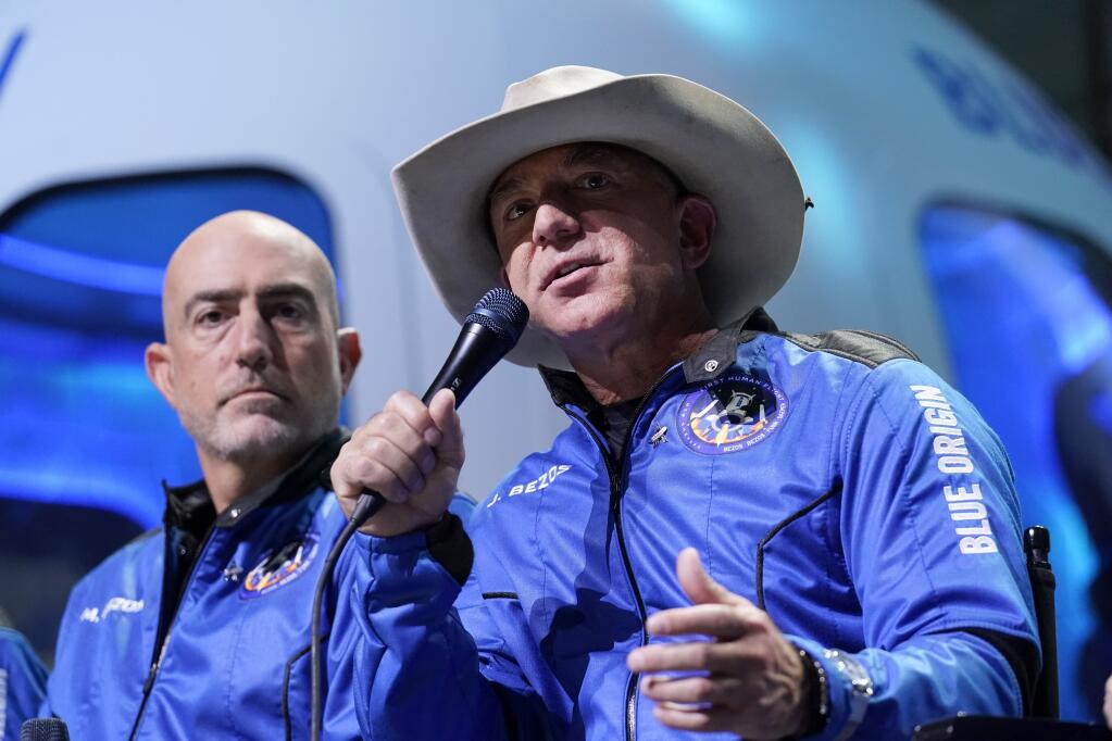 Mark Bezos, left, listens as his brother Jeff Bezos, founder of Amazon and space tourism company Blue Origin, describes the experience after their launch from the spaceport near Van Horn, Texas, Tuesday, July 20, 2021. (AP Photo/Tony Gutierrez)