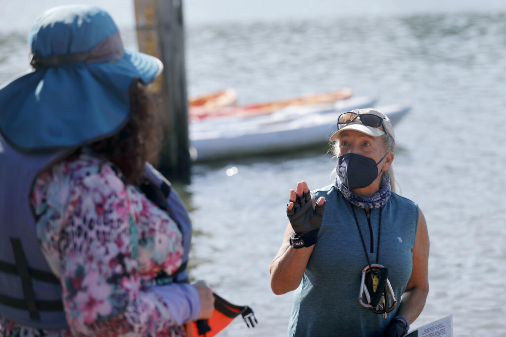 Suki Waters, owner of WaterTreks EcoTours, gives safety information to a kayaker in Jenner, Calif., on Sunday, February 13, 2022.(Beth Schlanker/The Press Democrat)