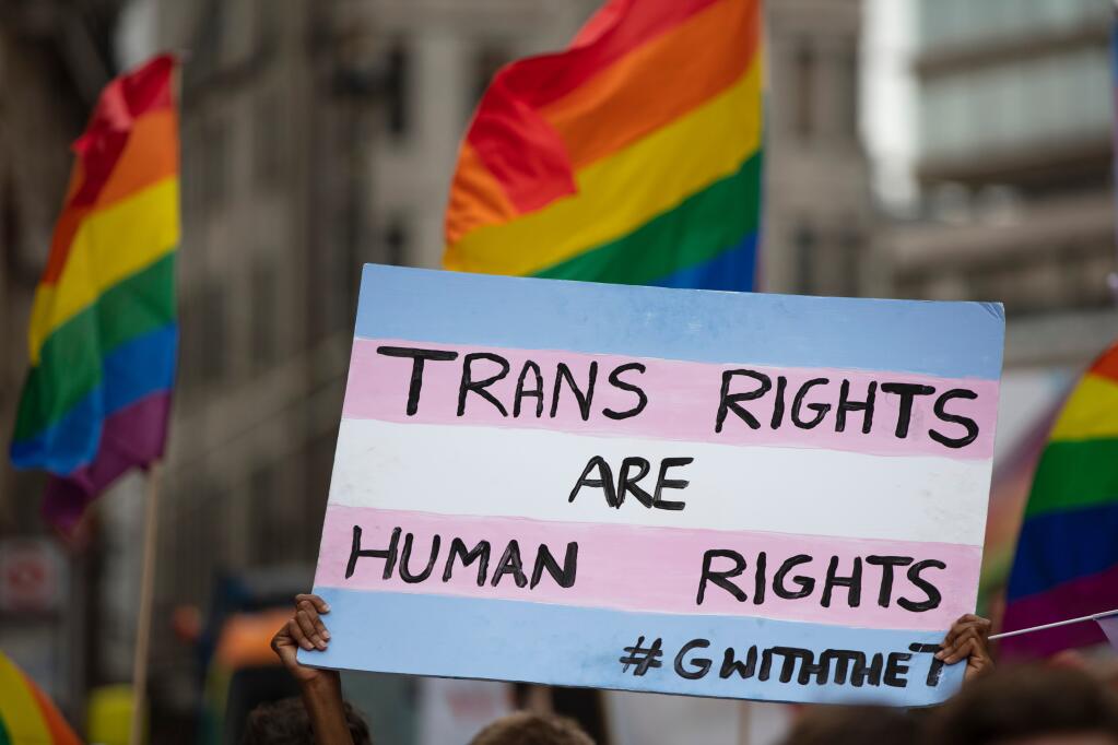 Transgender rights activists hold up a sign during a Pride parade. Gazette file photo.