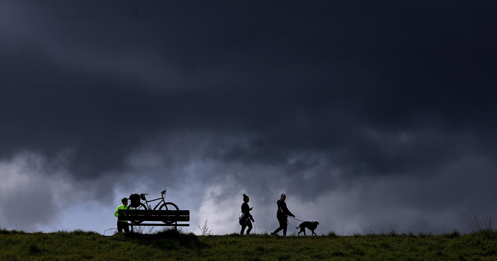 Low clouds obscure the horizon as people get their daily exercise at Spring Lake, Tuesday, March 7, 2023 in Santa Rosa. (Kent Porter / The Press Democrat) 2023