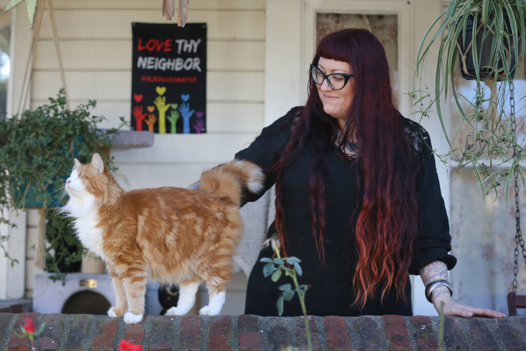 Anna Hill pets her cat, Murdock, outside her home in Santa Rosa on Monday, Dec. 14, 2020. (Beth Schlanker / The Press Democrat)