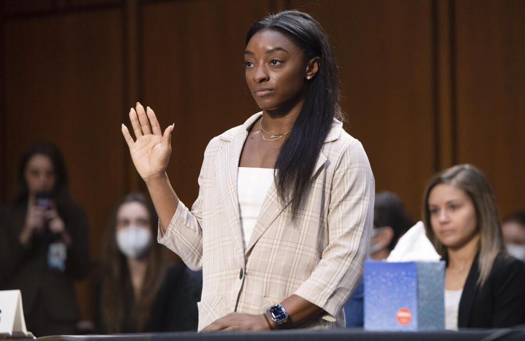 United States Olympic gymnast Simone Biles is sworn in during a Senate Judiciary hearing about the Inspector General's report on the FBI's handling of the Larry Nassar investigation on Capitol Hill, Wednesday, Sept. 15, 2021, in Washington. Nassar was charged in 2016 with federal child pornography offenses and sexual abuse charges in Michigan. He is now serving decades in prison after hundreds of girls and women said he sexually abused them under the guise of medical treatment when he worked for Michigan State and Indiana-based USA Gymnastics, which trains Olympians. (Saul Loeb/Pool via AP)