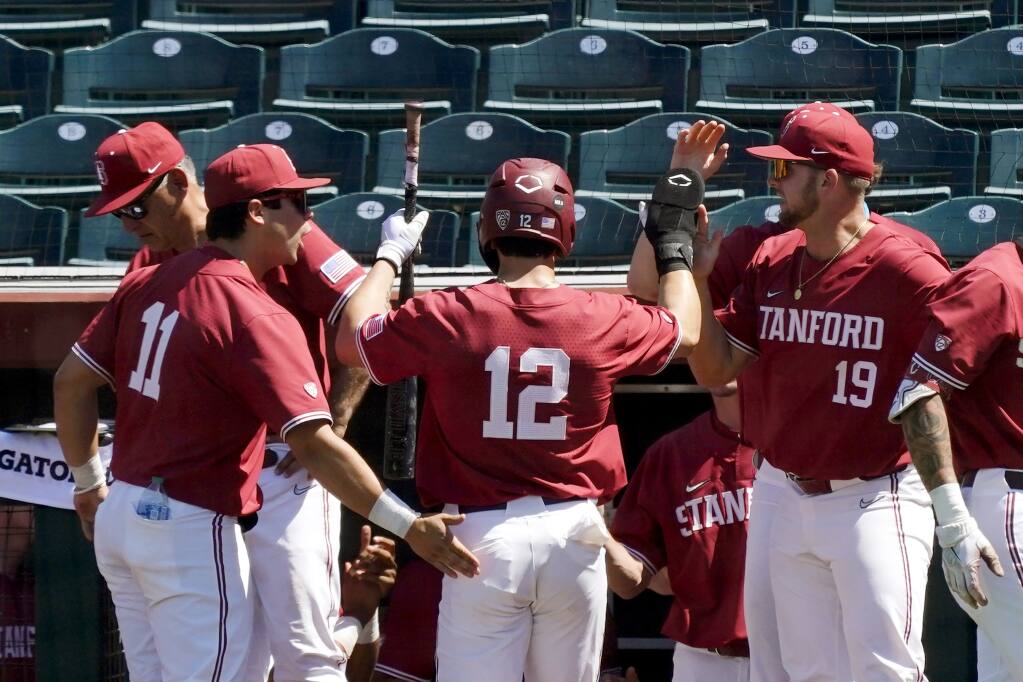 Stanford’s Tommy Troy, center, is congratulated by Alberto Rios, left, and Henry Gargus after scoring against Arizona State during the fifth inning of a first-round Pac-12 tournament game on Wednesday, May 25, 2022, in Scottsdale. (Ross D. Franklin / ASSOCIATED PRESS)