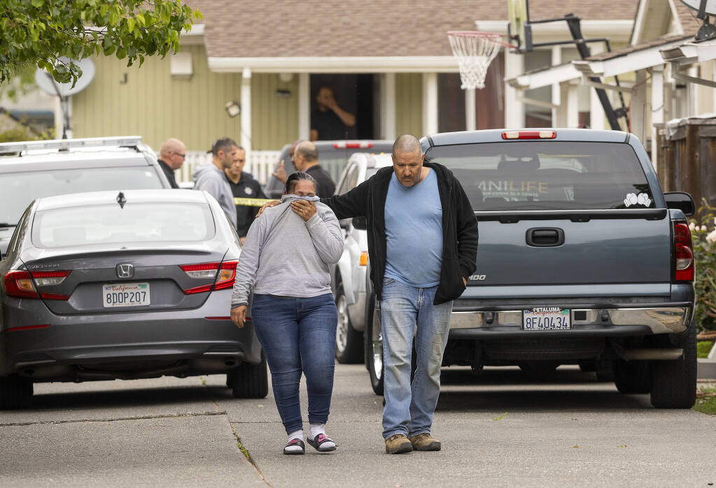 A man comforts a distraught woman as they walk away from a home on Aston Avenue in Santa Rosa where two people were found dead on Thursday, May 5, 2022. Santa Rosa police were investigating.  (John Burgess / The Press Democrat)