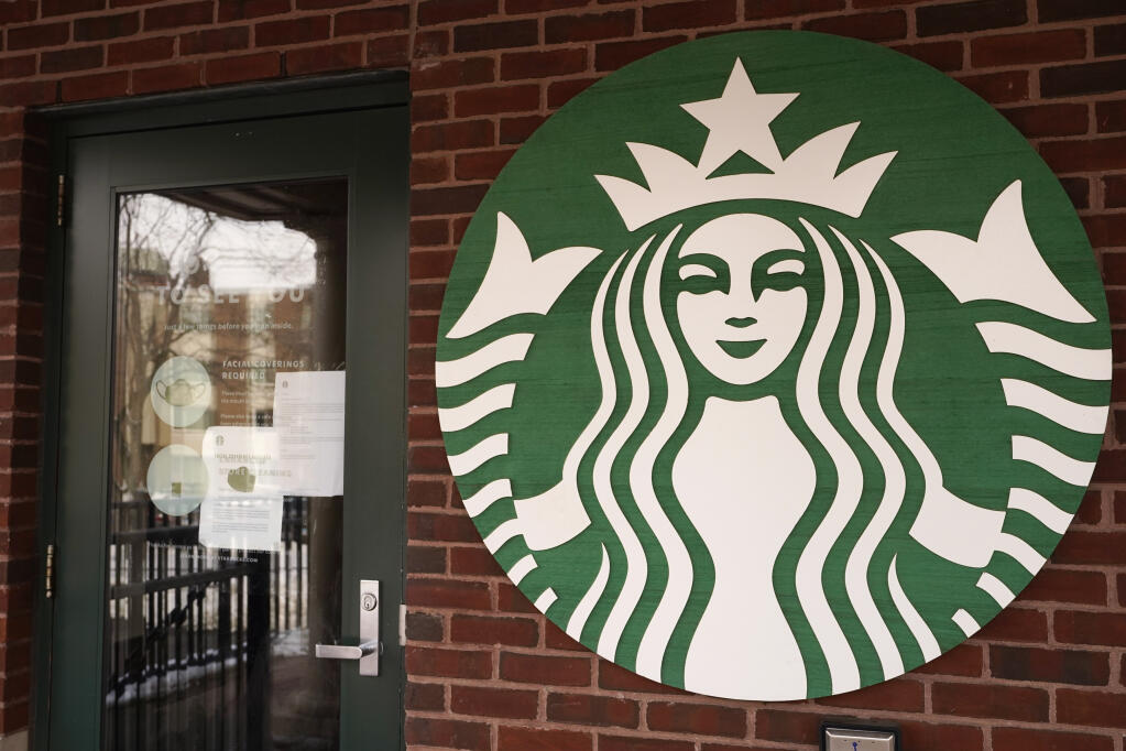 A Starbucks coffee company logo and information signs are seen at Palatine Metra train station in Palatine, Ill., Wednesday, Jan. 6, 2021. (AP Photo/Nam Y. Huh)
