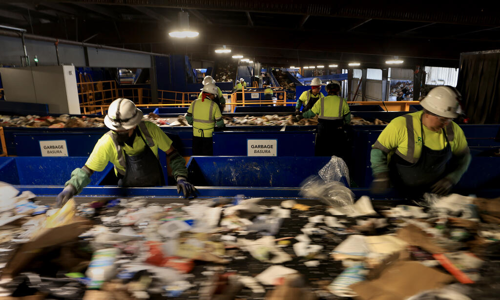 Workers sort out non recyclables at Recology Sonoma Marin as the company unveils their state-of-the-art recycling facility, Thursday, Jan. 25, 2024, in Santa Rosa.  (Kent Porter / The Press Democrat)