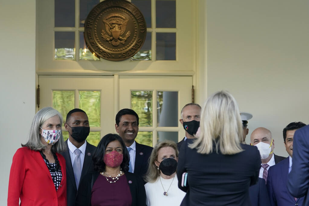 Members of the Congressional Progressive Caucus, from left, Katherine Clark, D-Mass., Rep. Ritchie Torres, D-N.Y., Rep. Pramila Jayapal, D-Wash., Rep. Ro Khanna, D-Calif., Rep. Debbie Dingell, D-Mich., Rep. Jared Huffman, D-Calif., Rep. Mark Pocan, D-Wis., and Rep. Jimmy Gomez, D-Calif., pose for a photo outside the West Wing of the White House in Washington, Tuesday, Oct. 19, 2021, following their meeting with President Joe Biden. (AP Photo/Susan Walsh)
