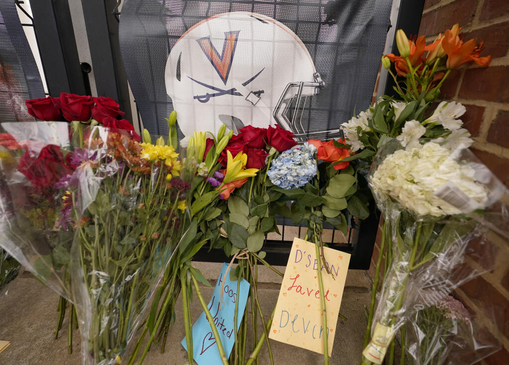 Flowers and notes left in memory of three football players killed in a campus shooting Monday line a walkway at Scott Stadium at the University of Virginia in Charlottesville. (Steve Helber / ASSOCIATED PRESS)